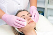 © Elena - cosmetology. Close up picture of lovely young woman with closed eyes receiving facial cleansing procedure in beauty salon.
