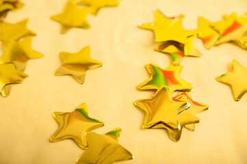 Wall Mural - Christmas background in gold color. Yellow confetti stars out of focus.