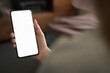 © GCapture - Young woman hold smartphone with white screen while sitting on a couch