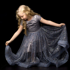 Wall Mural - A little girl in a long, elegant dress of a princess on a black background.