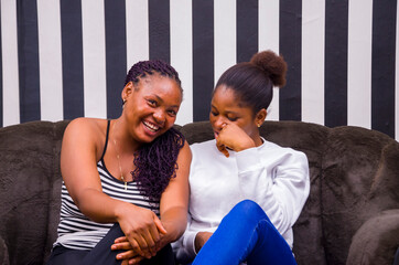 two beautiful african ladies feeling happy as they discuss.