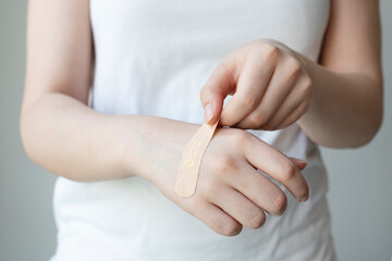 Hand with adhesive plaster that covering a slight injury, close-up