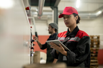 Aufkleber - Young pretty female engineer with tablet entering data from control panel
