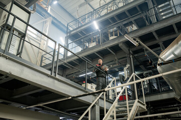 Poster - Bald mature foreman with touchpad working inside polymer processing factory