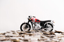 Modern Classic Motorcycle Model On Many Of Coins Background, Finance Concept.