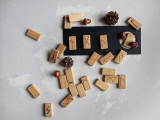 
runes made by hand from wood on a gray background with different objects around