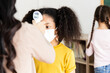 © JR-50 - A group of Kids students wearing masks lined up waiting for woman teachers to Check Fever by Digital Thermometer in the classroom for Scan and Protect from Coronavirus Outbreak - Healthcare Concept