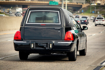 A black hearse driving down a freeway