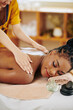 © DragonImages - Cropped image of young Black woman enjoying back massage with oils in spa salon