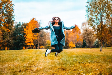 Wall Mural - Beautiful woman walking through autumn colored park
