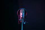 Studio microphone and pop shield on mic in the empty recording studio with copy space. Performance and show in the music business equipment.
