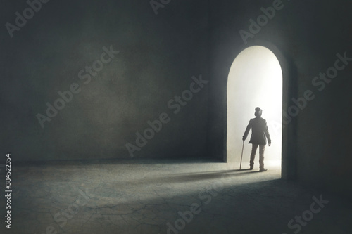 Fotomural man entering in a mysterious light door, surreal concept