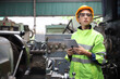 © torsakh - A Engineer woman using tablet or computer for inspect or checking or adjust or operate control the machine in workshop factory, the technician repair or maintenance part or equipment