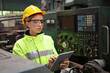 © torsakh - A Engineer woman using tablet or computer for inspect or checking or adjust or operate control the machine in workshop factory, the technician repair or maintenance part or equipment