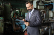 © torsakh - A smart professional business manager wear suit is working or inspect and radio to ordering in factory or production line, smart leader or entrepreneurship concept