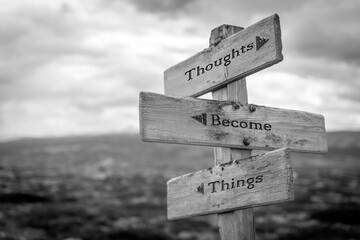 Wall Mural - thought become things text quote on wooden signpost outdoors in black and white.
