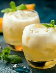 Wall Mural - Refreshing Cantaloupe Melon cocktail with ice and mint on rustic table