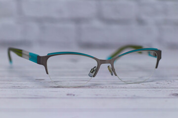 Stylish glasses with transparent lenses lie on a light wooden surface