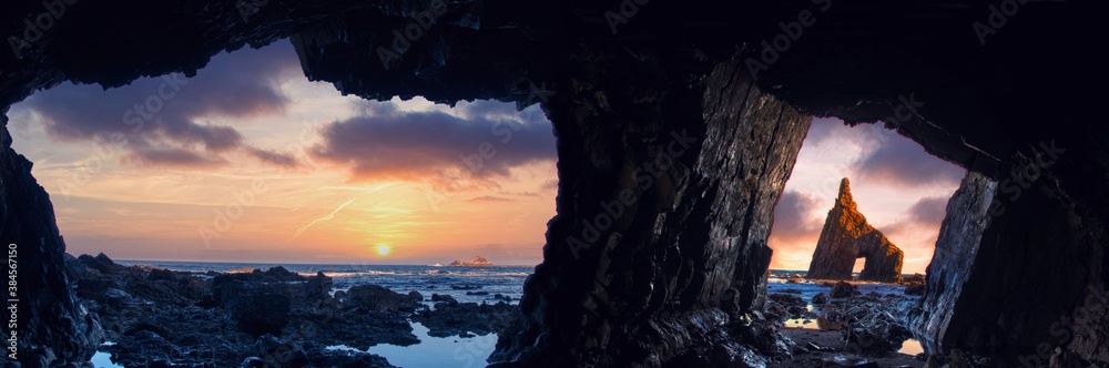 Sunrise from inside the cave of Campiecho in Asturias, Spain. - obrazy, fototapety, plakaty 