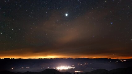 Wall Mural - amazing time-lapse of the night sky rotating above a small town.