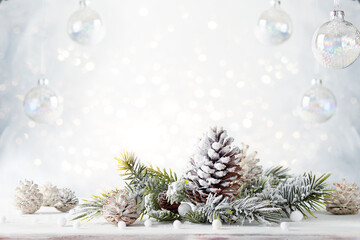 Christmas still life with snowy pine cones, baubles and  fir branches on light background. Winter or Christmas festive concept.