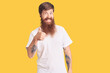 © Krakenimages.com - Handsome young red head man with long beard wearing casual white tshirt doing happy thumbs up gesture with hand. approving expression looking at the camera showing success.
