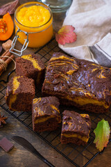 Wall Mural - Baking Thanksgiving Day. Homemade chocolate brownie cake dessert with pumpkin puree and spices on a rustic wooden background.
