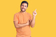 © Krakenimages.com - Young hispanic man wearing casual clothes smiling happy pointing with hand and finger to the side