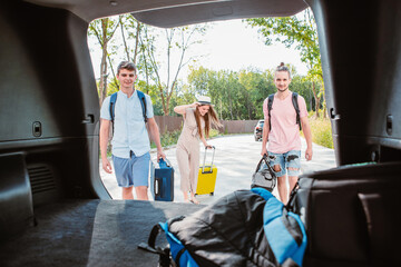 Wall Mural - friends load car trunk with baggage