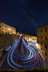 Wall Mural - night view with light trails of cars around corner on hillside town