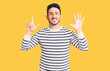 © Krakenimages.com - Young hispanic man wearing casual clothes showing and pointing up with fingers number seven while smiling confident and happy.
