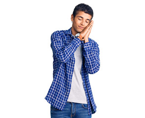 Young african amercian man wearing casual clothes sleeping tired dreaming and posing with hands together while smiling with closed eyes.