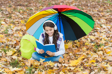 Resting after long day. happy childhood. back to school. girl in headset relax in park. enjoy fall in forest. listen to music. online courses education. autumn kid under umbrella. read the book