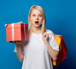 Canvas Print - Blonde in white t-shirt with shopping bags and gift box