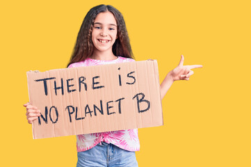 Cute hispanic child girl holding there is no planet b banner smiling happy pointing with hand and finger to the side