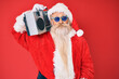 © Krakenimages.com - Old senior man wearing santa claus costume and boombox thinking attitude and sober expression looking self confident