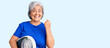 © Krakenimages.com - Senior woman with gray hair holding weight machine to balance weight loss screaming proud, celebrating victory and success very excited with raised arms