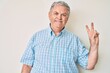 © Krakenimages.com - Senior grey-haired man wearing casual clothes smiling with happy face winking at the camera doing victory sign. number two.