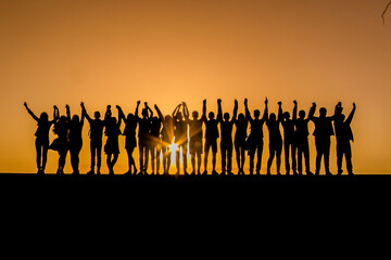 Silhouettes of children against the sunset with their hands up. Goodbye school. Prom. Banner. A place for text. Photo in the background of the sun. Friendship.