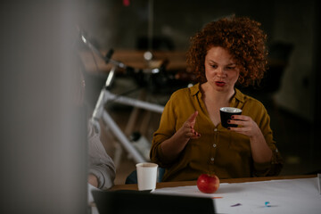 Wall Mural - Businesswomen drinking coffee in office.. Colleagues discussing work in office.