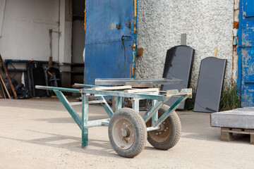 Handcart for transporting natural stone next to a granite workshop.