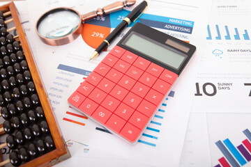 Wall Mural - Calculator and abacus, magnifying glass and signature pen on business documents