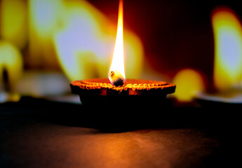 Wall Mural - Clay diya candle illuminated in Dipavali, Hindu festival of lights. Traditional oil lamp on dark background