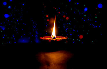 Wall Mural - Clay diya candle illuminated in Dipavali, Hindu festival of lights. Traditional oil lamp on dark background