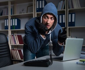 young hacker hacking into computer at night