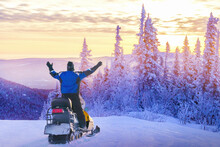 Man Driving Snowmobile In Snowy Forest. Concept Freedom In Winter Travel.