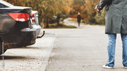 Fotografía man walking to their parked car after stroll in autumn park