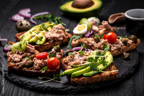 sandwich tuna fish collection. Delicious breakfast or snack. Toasts with tuna delicious healthy food on a dark background, Top view