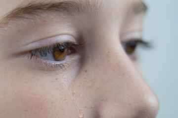 Brown eyes with tears close up. Tear drop on girl's eye