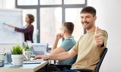 Canvas Print - business and people concept - happy smiling man showing thumbs up at office conference